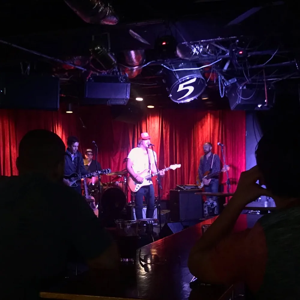 Brad Byrd and his band on the red-curtained stage at The 5 Spot in Nashville, with guests watching from the bar